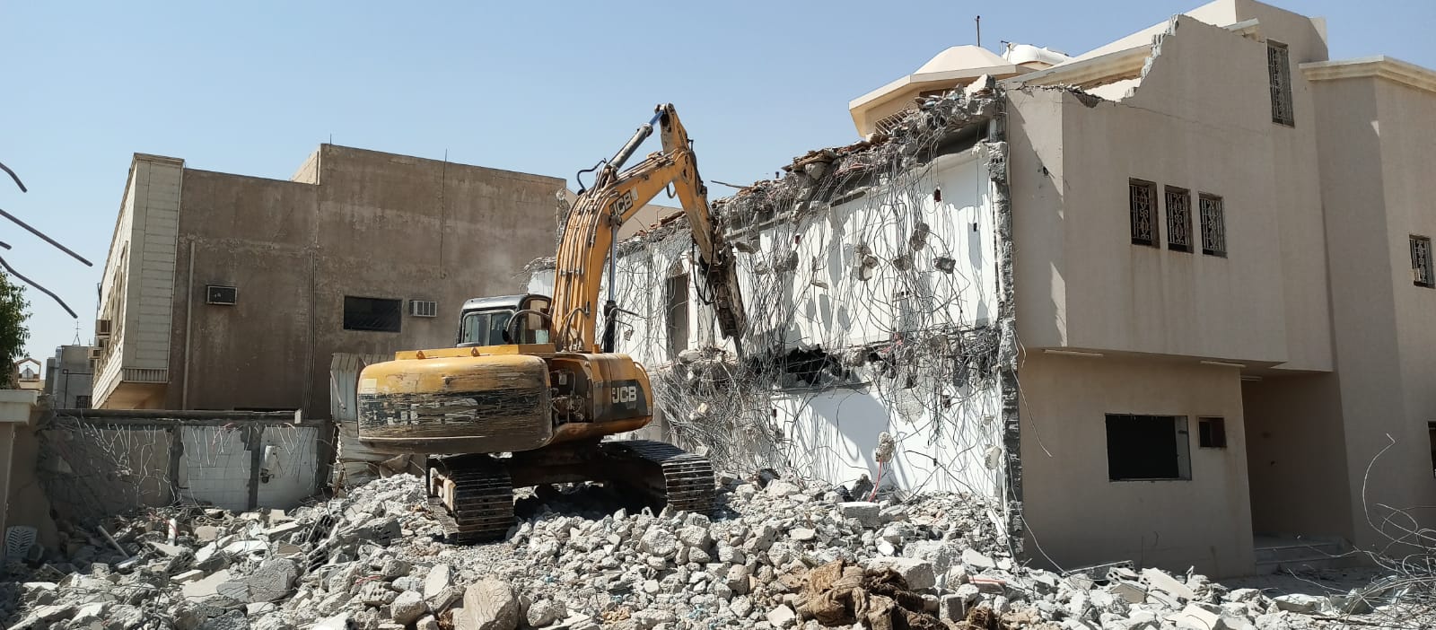 هدم مبنى باستخدام حفارة